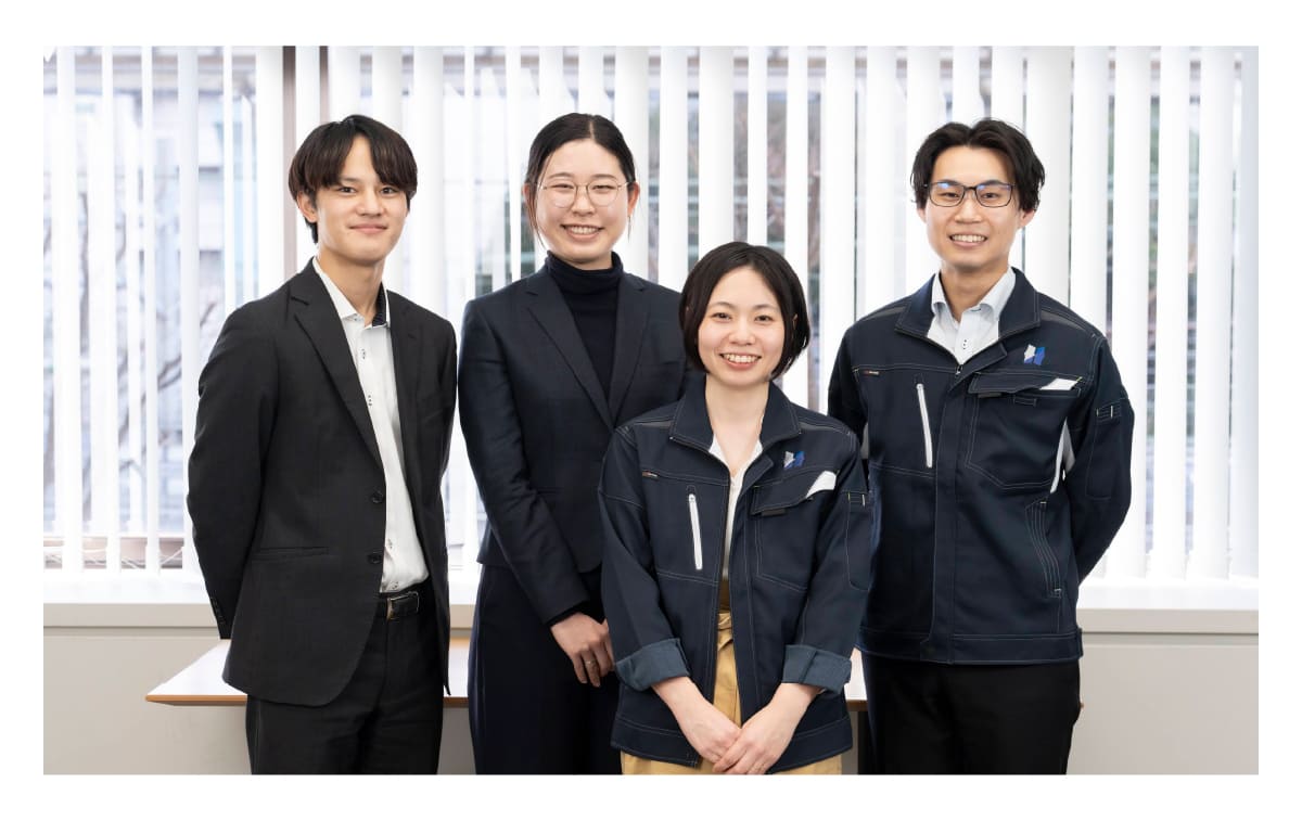 先輩社員と3人の若手社員が笑顔で映っている職場の風景