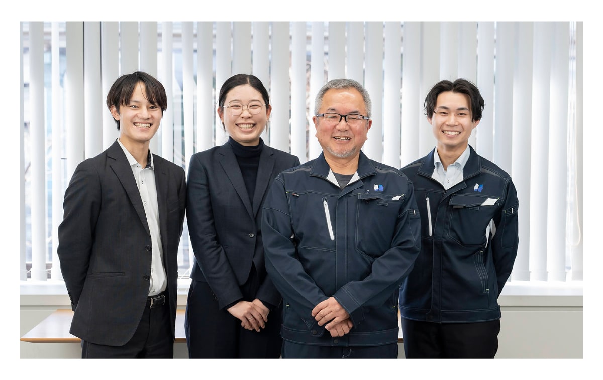 先輩社員と3人の若手社員が笑顔で映っている職場の風景
