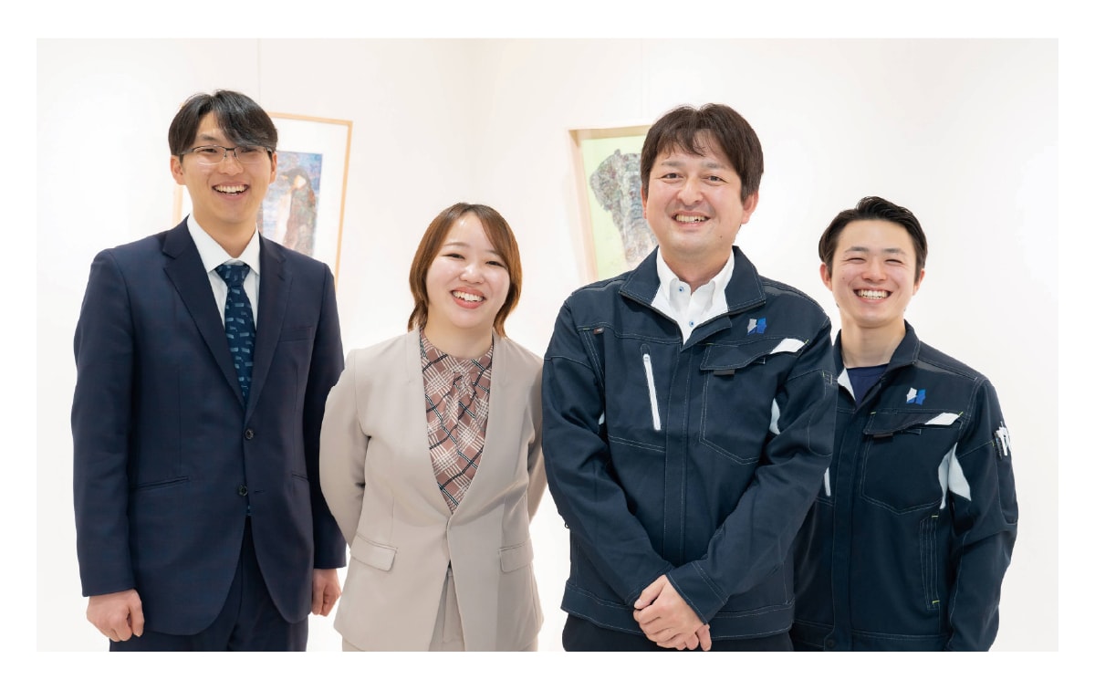 先輩社員と3人の若手社員が笑顔で映っている職場の風景