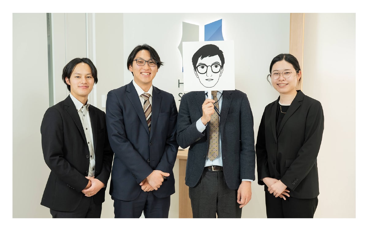 先輩社員と3人の若手社員が笑顔で映っている職場の風景